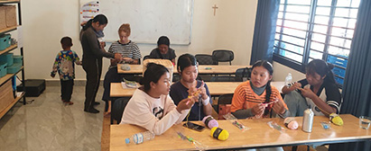 En lokal kvinde fra Run Ta Ek underviser de unge piger på Living Hope Center i at hækle. Hækleprojekt på Living Hope Center