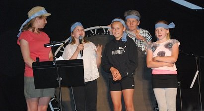 Tre juniorpiger fra Stubbekøbing præsenterer deres sang på Landsteltlejr 2018